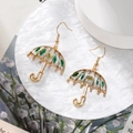 Detailed close-up of golden umbrella earrings featuring real green leaves and dried flowers - Green Leaf Umbrella