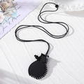 Detail of black leather pouch necklace with white stitching and woven cord on white surface - Vase Shape / Black
