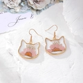 Detailed macro view of cat-shaped gold drop earrings with pink dried daisy flowers - Pink Chrysanthemum Cat