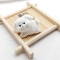 Detail view of a cute white flocked puppy keychain on a wooden tray with silver ring - Flocking White Dog