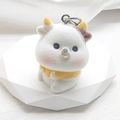 Close-up of white flocked animal keychain with yellow scarf on geometric stand - Flocking Yellow Clothes Cow