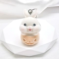 Detailed view of a soft flocked white and orange cartoon rabbit keychain on a stand - Flocking Pumpkin Rabbit