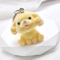 Detailed view of yellow flocked puppy keychain with a metal ring on a white pedestal - Flocking Yellow Tilted Head Dog
