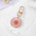 Luminous round resin keychain with pink dried daisy flower and golden metal clasp - Pink Daisy