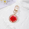 Luminous red daisy dried flower keychain with gold metal frame and round resin pendant - Red Daisy