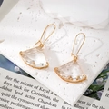 Elegant geometric fan-shaped crystal drop earrings with gold metal hooks on stone background - Clear