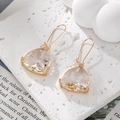 Macro detail of geometric crystal earrings with triangle facets and golden hooks - Clear