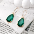 Detalle de pendientes elegantes de cristal verde esmeralda en gota con montura dorada - Verde