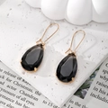 Detalle de pendientes de cristal de gota gris humo con corte facetado y engaste dorado - Negro