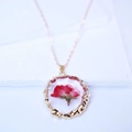 Macro detail of red dried rose inside transparent resin pendant with gold wavy frame - Red Style 2