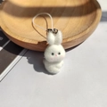 Close-up detail of a white flocked bunny keychain with soft fur texture and metal clasp - Head-turning White Bunny