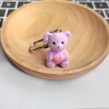 Cute purple flocked teddy bear keychain with pink heart on a small wooden tray - Purple Bear