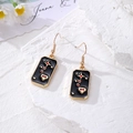 Detail view of tarot style earrings with gold star motifs and black enamel on stone - Eye