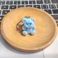 Dettaglio di un simpatico portachiavi a forma di orsetto blu con fiocco rosa e gancio - Orso Abbraccio Blu