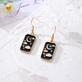 Golden alloy tarot drop earrings featuring black enamel moon and star charms - Cloud