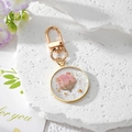 Handmade clear resin daisy keychain with dried pink flowers and gold foil accents - Pink September Daisy