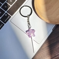 Detailaufnahme lila Stern-Lutscher-Schlüsselanhänger mit Glitzer auf Laptop-Tastatur - Violetter Stern Lutscher