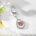 Dettaglio portachiavi a goccia d'argento con rosa rossa essiccata e scaglie di foglia d'oro - Rosa Piccola