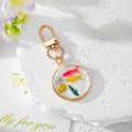 Détail macro du porte-clés en résine avec fleurs bleues et petits poissons rouges - Petit Poisson Avec Fleurs Bleues et Jaunes