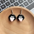 Funny resin earrings featuring black lips and pink tongue on a wooden tray background - Tongue Out Black Lips