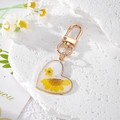 Handgefertigter herzförmiger Gold-Schlüsselanhänger mit gelben Trockenblumen und Ring - Weiße Perle Gänseblümchen