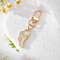 Porte-clés aile dorée avec fleurs séchées sur un support en pierre blanche - Blanc Fleuri