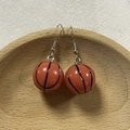 3D basketball-shaped resin hook earrings in orange color on a wooden tray - Basketball