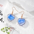 Detailaufnahme herzförmiger blauer Harz-Ohrringe mit goldener Kupferdraht-Einfassung - Verlauf Blau