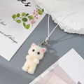 Close-up of white flocked kitten keychain with woven strap and silver metal clasp - Beige Cat