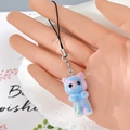 Close-up of a blue and pink flocked kitten charm with silver lobster clasp and strap - Blue Gradient Cat