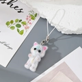 Detail of a white flocked kitten keychain with colorful paint splatters and silver clasp - White Gradient Cat