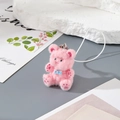 Close-up of a cute pink flocked bear keychain with blue bowtie and silver metal attachment - MR75 Pink Bear