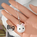 Close-up of a white flocked kitten head charm with pink ears on a metal lobster clasp - Large White Cat Head