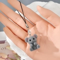 Detail view of a gray flocked resin bear charm with a black lanyard and silver clasp - MR49 Gray Bear