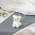 Close-up of a white flocked bear charm with a silver metal clasp and a white lanyard - MR07 White Bear