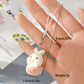 Handheld view of a white flocked bunny keychain with size dimensions and silver clasp - Rabbit with Orange Decor (7MR04)
