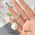 Detail showing miniature 1.8cm white flocked rabbit charm with lobster clasp and phone strap - Sitting White Rabbit (8MR84)