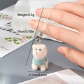 Détail d'un porte-clés chien beige avec pull vert et dimensions montrées de 10 cm - Chien Beige en Haut Vert (9MR26)