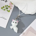 Close-up of fluffy white cat keychain with pink ear details and soft plush texture - White Laying Cat