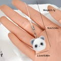 Detail view of a 9cm panda plush pendant with metal lobster clasp on a model's hand - Panda Head