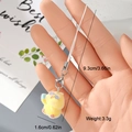 Macro shot of cute yellow flocked duckling keychain with braided lanyard and metal clasp - Bird with Blue Accessories (6MR59)