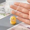 Close-up of a yellow flocked chick keychain with a pink bow and heart pattern detail - Yellow Chick with Bow (8MR87)
