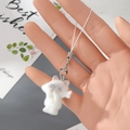 Detailopname van een witte geflokte kitten hanger die met de hand wordt vastgehouden - Witte geflokte kat (1MR86)