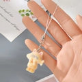Macro-opname van oranje kitten hanger met zilveren karabijnsluiting vastgehouden - Oranje geflokte kat (4MR86)