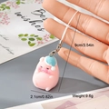 Détail de la breloque cochon en résine rose avec chapeau bleu sur fond de carte cadeau - Cochon Rose avec Chapeau Bleu (FMR66)
