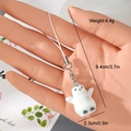 Detail showing a small flocked penguin keychain with dimensions held in hand - Penguin Shape Style (14MR82)