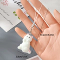 Nahaufnahme des weißen Beflockten Katzenanhängers mit Maßen und rosa Ohrendetails - Spielerische weiße beflockte Katze (21MR73)