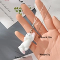 Detailaufnahme eines weißen geflockten Katzenanhängers mit rosa Pfoten und Maßen - Sich streckende weiße Katze (22MR73)
