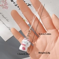 Makro-Detail eines weißen beflockten Glückskatzen-Anhängers mit rotem Halsband und Karabiner - Glückskatze mit rotem Schal (23MR72)