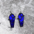 Makroaufnahme von Sarg-Ohrringen im Gothic-Stil mit blauem Spiegelglanz und Fledermausmotiven - Königsblaue Fledermaus